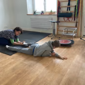 Séance de reflexes archaiques avec un enfant, au cabinet Neurolusk, posture au sol