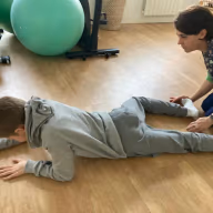 Séance de reflexes archaiques avec un enfant, au cabinet Neurolusk, posture au sol