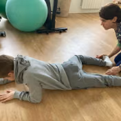 Séance de reflexes archaiques avec un enfant, au cabinet Neurolusk, posture au sol